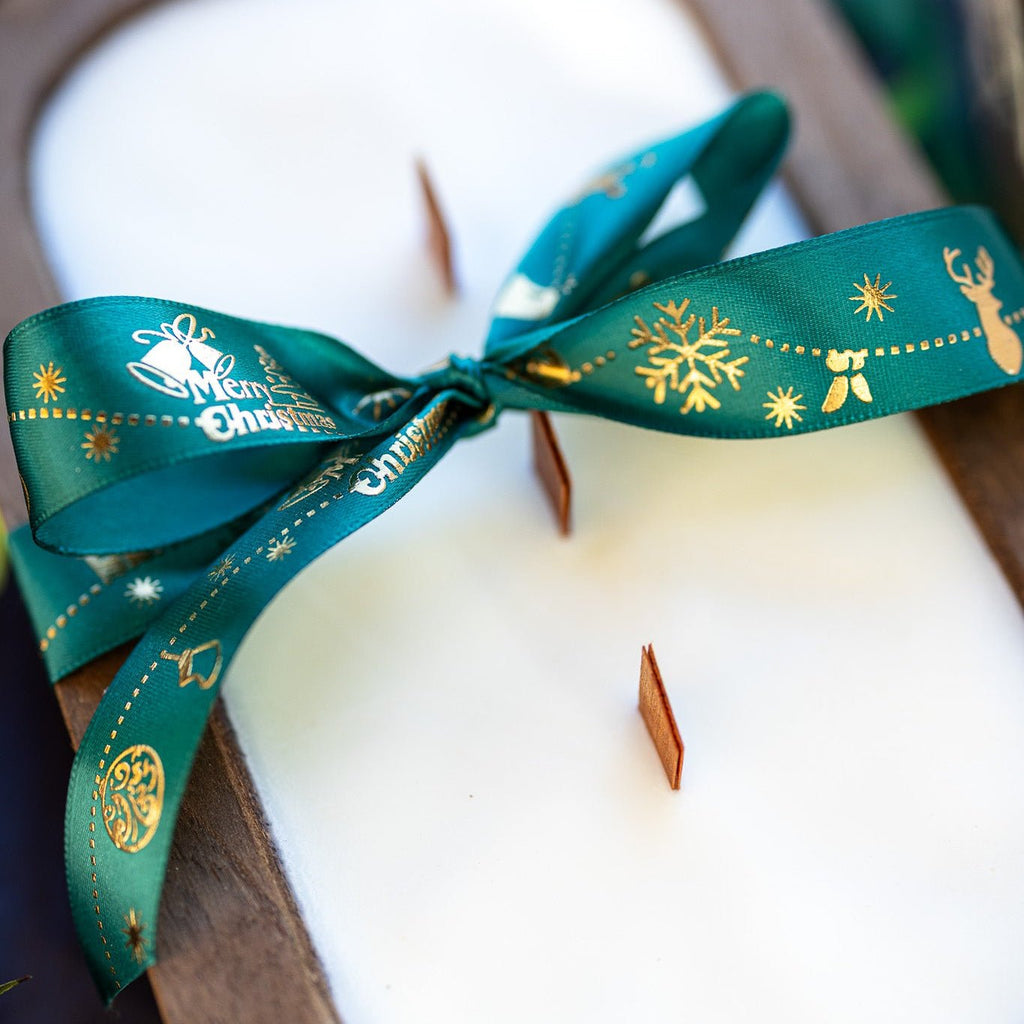 Wood dough bowl candle close-up of teal ribbon bow over white wax with wick tips