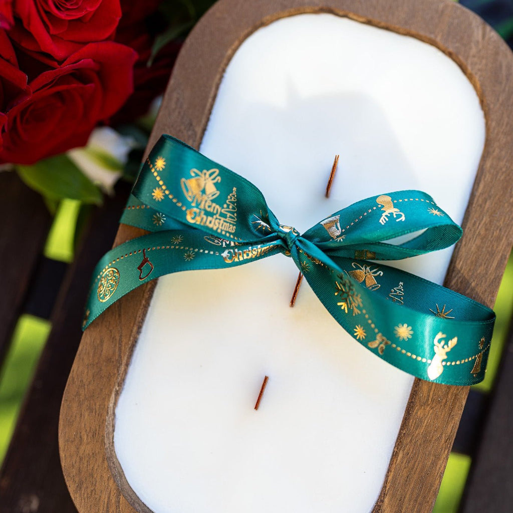 Wood dough bowl candle with teal ribbon bow over white wax, brown wooden dough bowl