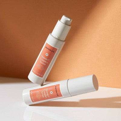 Naturium Vitamin C Complex Serum bottle and spare bottle with white caps, coral labels