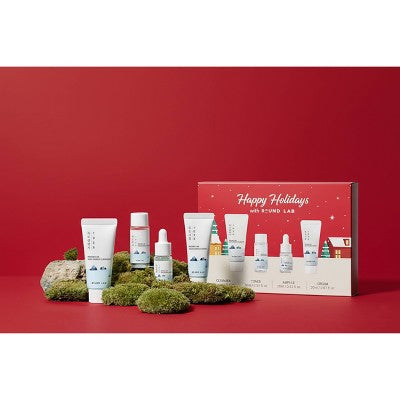 4-piece travel skincare gift set with skincare tubes and bottles in front row