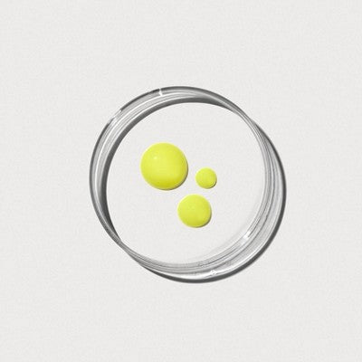 Small glass jar with three yellow gel droplets