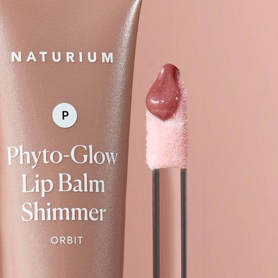 Close-up shimmer lip balm on applicator tip, rose-pink glittery texture