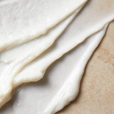 Thick white ceramide cream smear texture on skin