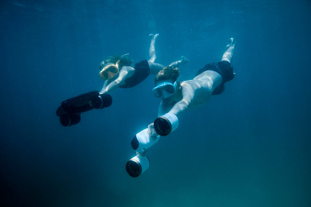 Underwater drone with camera housing, scuba divers underwater