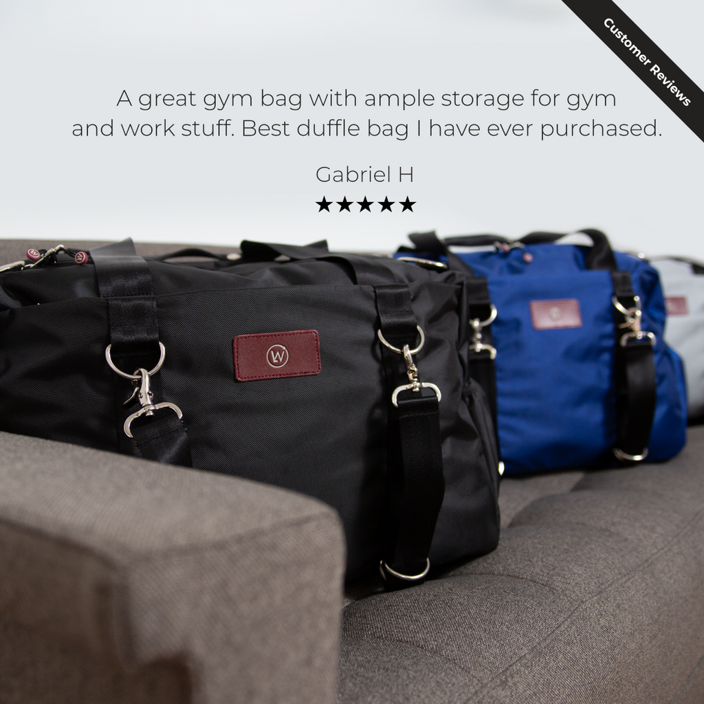 Black gym duffel bag with red logo patch, front zippers, and D-ring straps