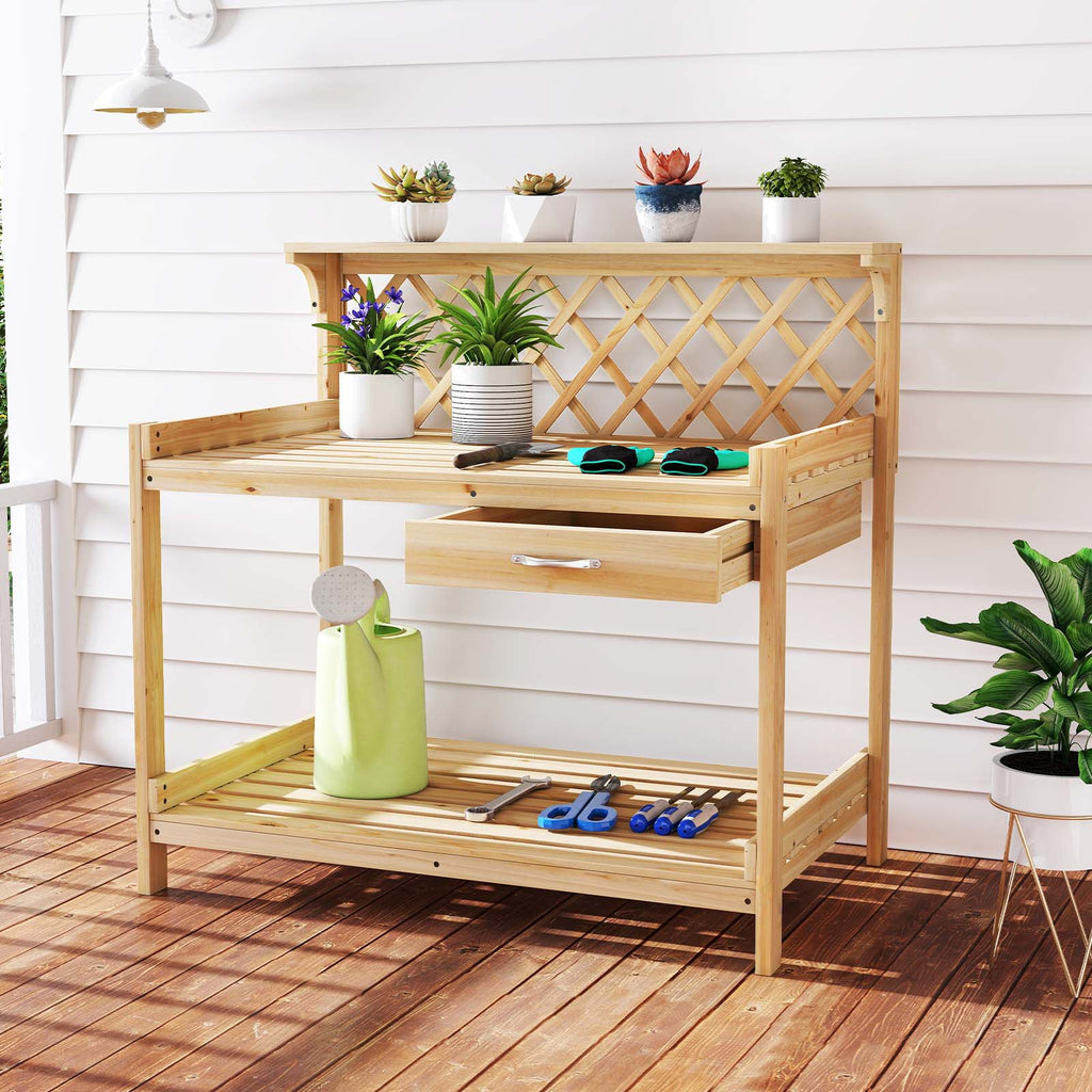 Wooden potting bench with lattice back, top shelf, pull-out drawer, potted plants