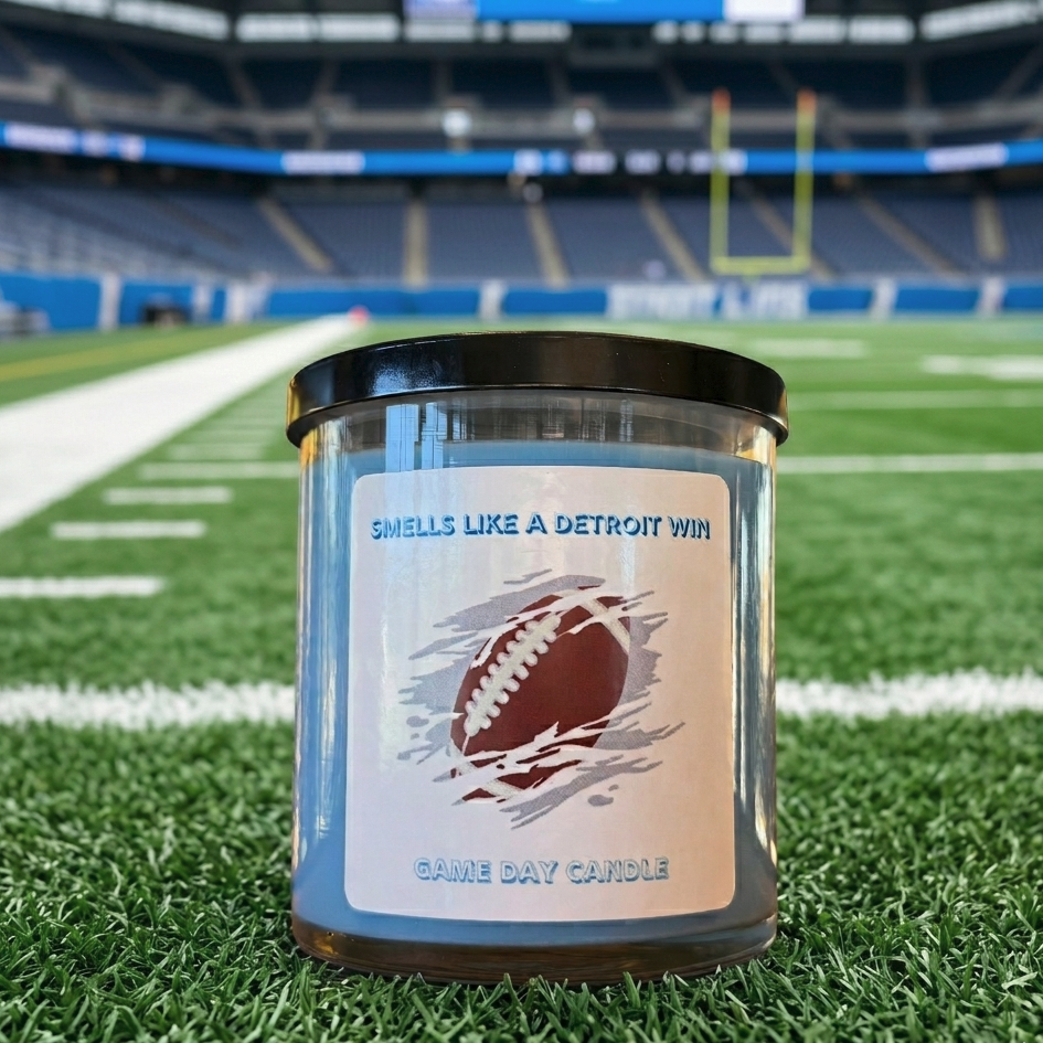 Blue game day candle in clear glass jar with football label and black lid