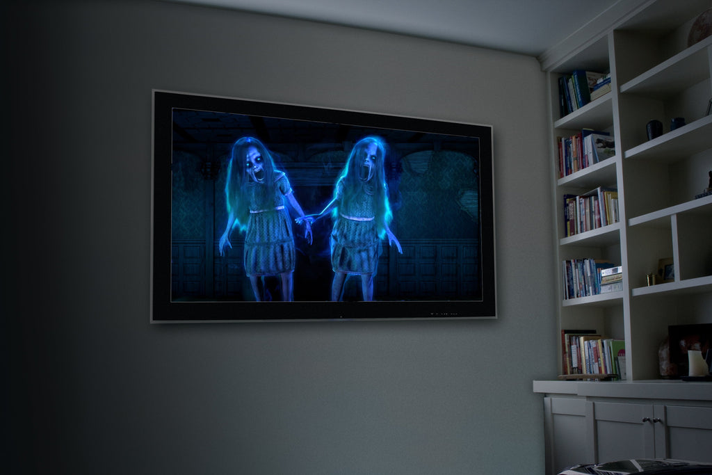 Wall-projected blue ghostly figures on a screen in a home room