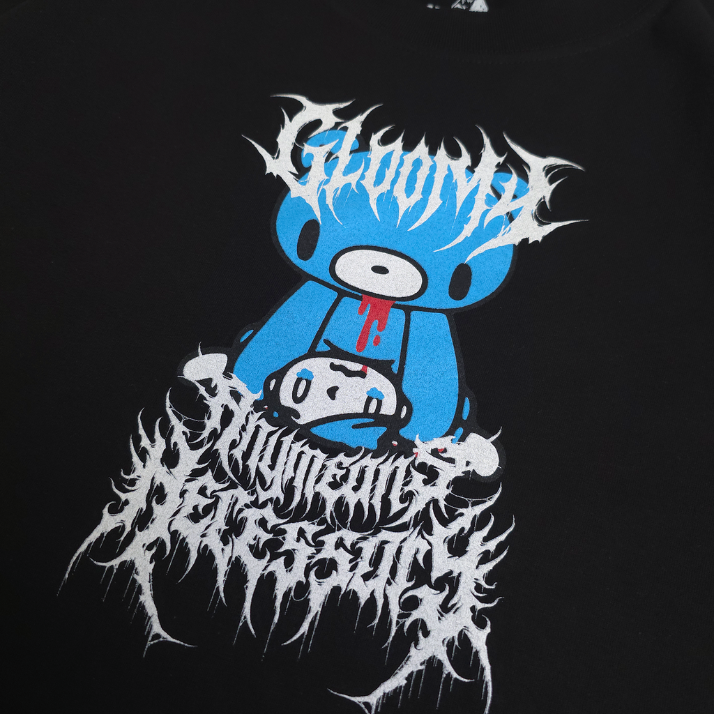 Close-up of black hoodie front print with blue character and white flame-style text