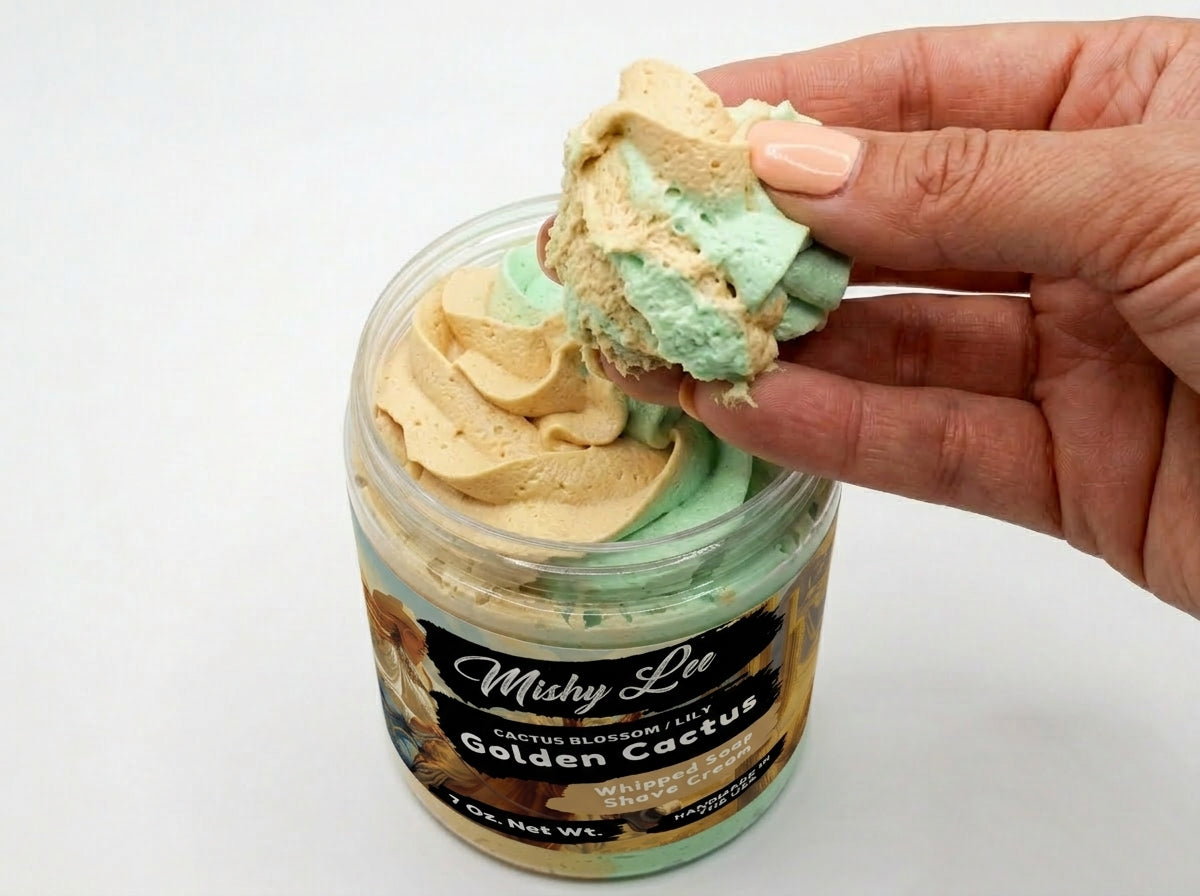 Whipped soap and shave cream scoop in hand showing gold and green swirled texture