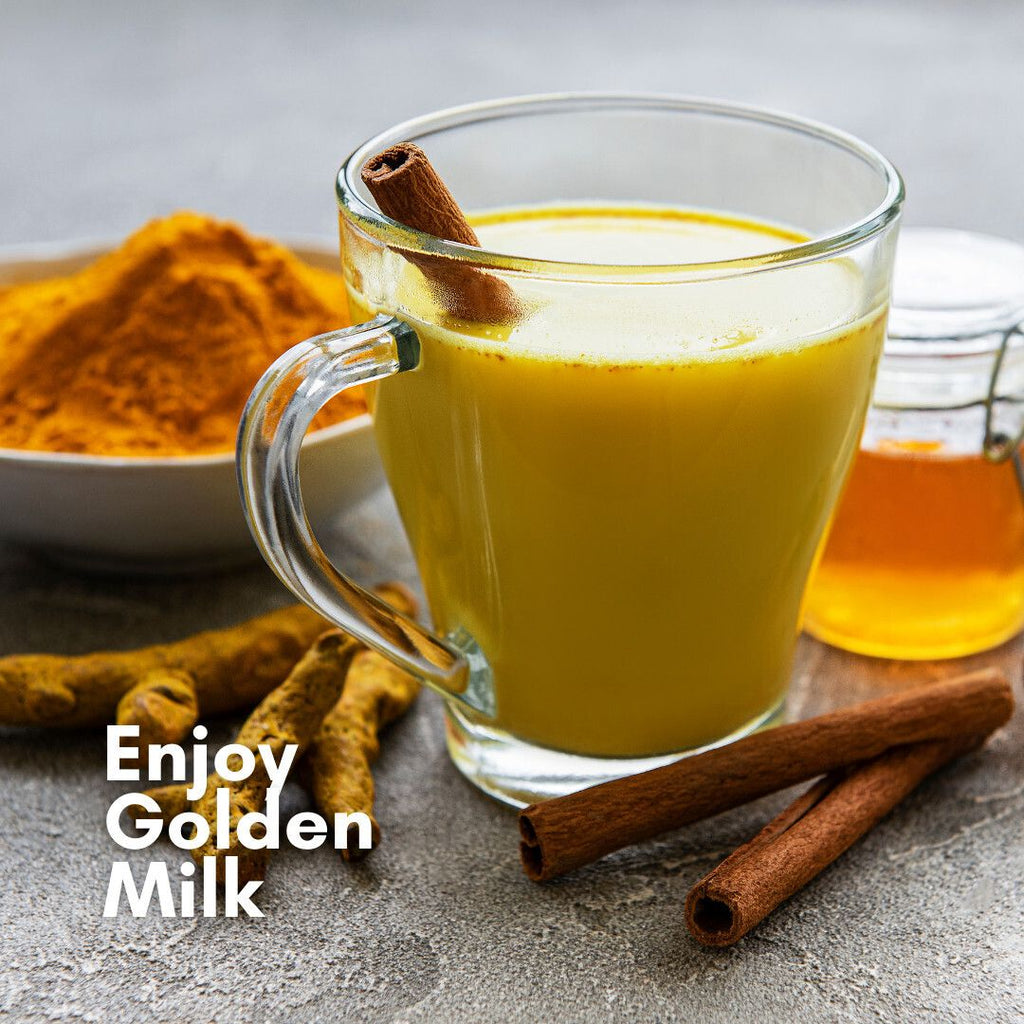 Golden turmeric drink in a glass mug with cinnamon sticks and turmeric root