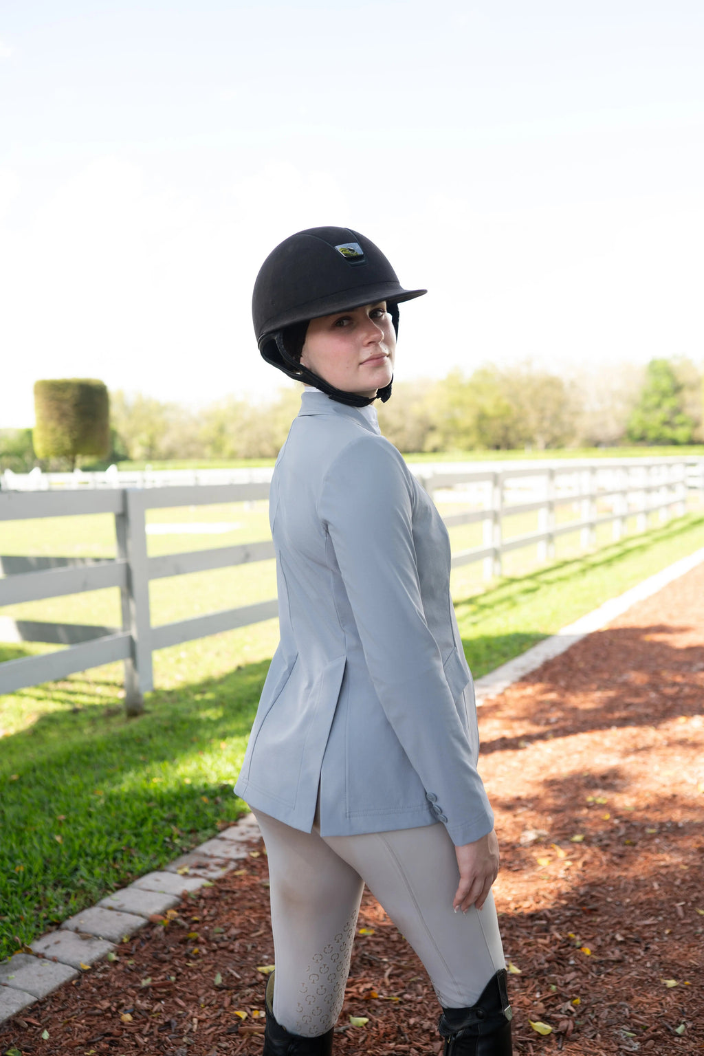 Cadet blue EQ show coat on rider, side view, notched lapels, three-button front, long sleeves