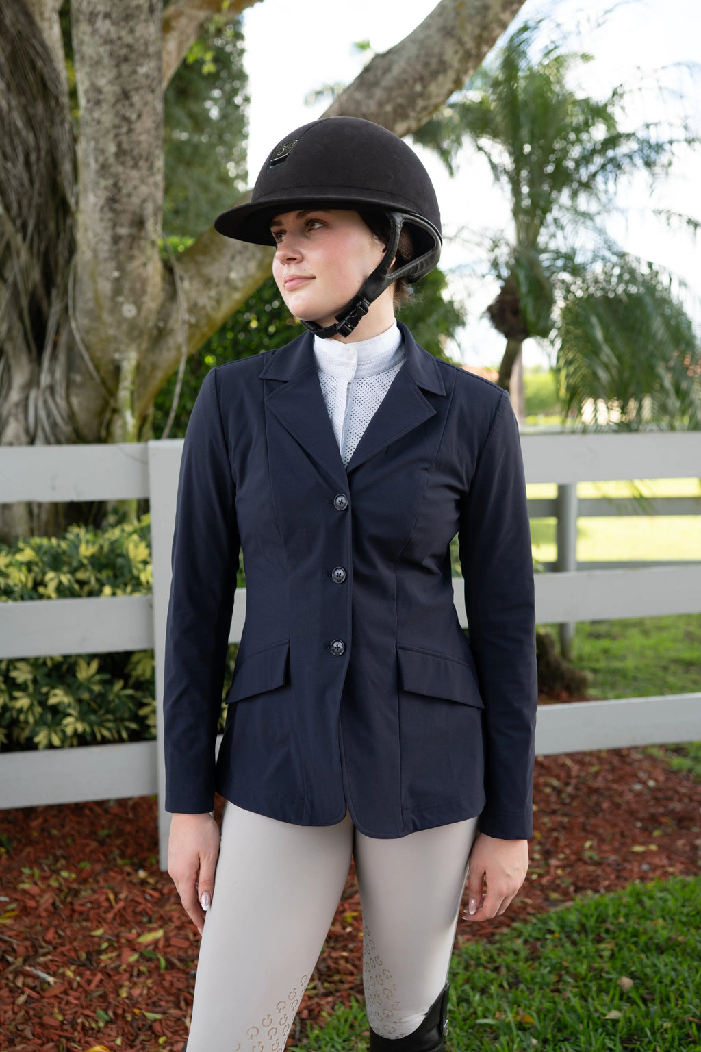 Navy ladies show coat with lapel and three-button closure, flap pockets at chest and waist