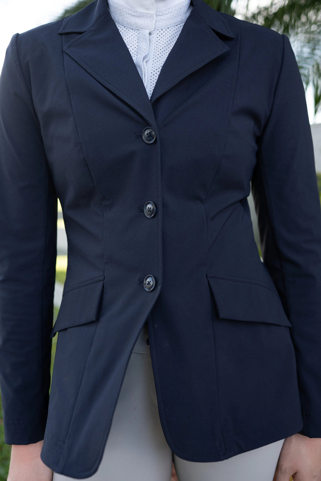 Navy show coat front close-up with lapel, three buttons, and flap pockets