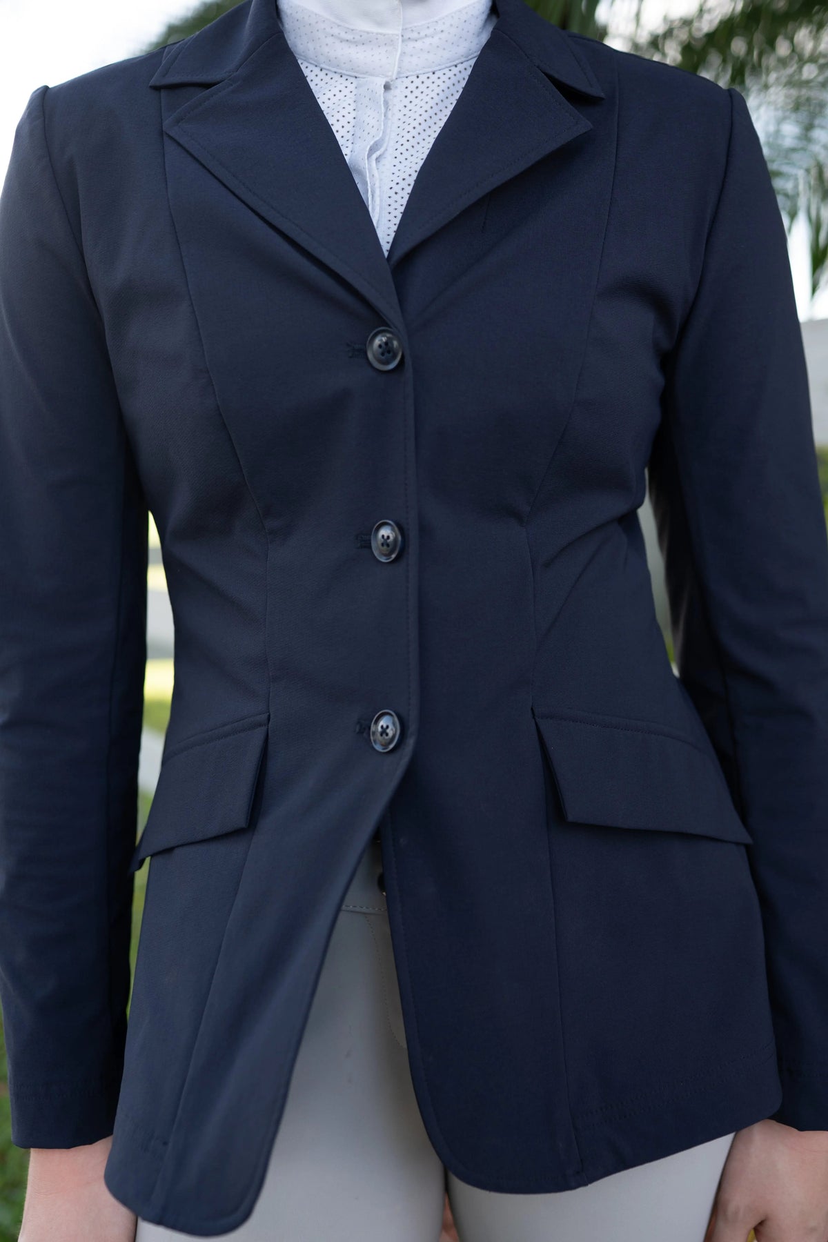 Navy show coat front close-up with lapel, three buttons, and flap pockets