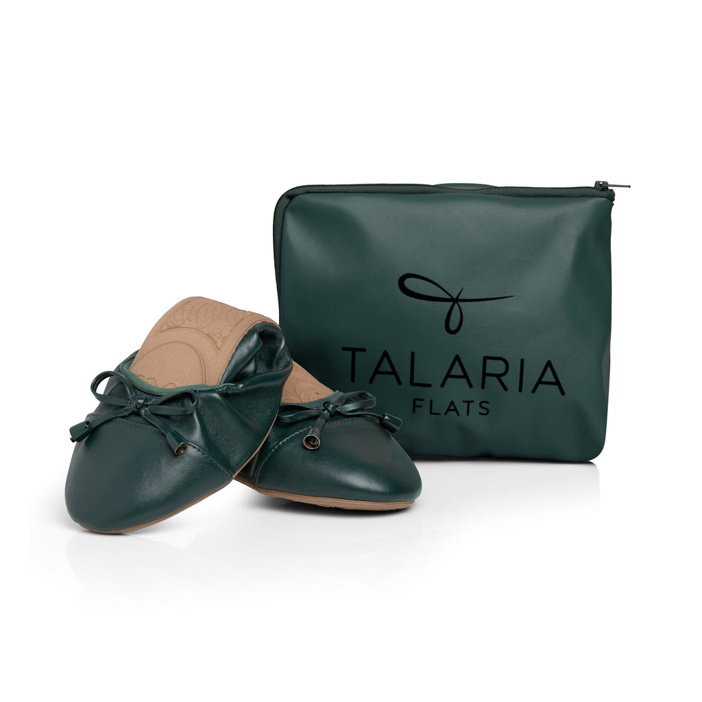 Dark green flats with tan insoles next to zip storage pouch