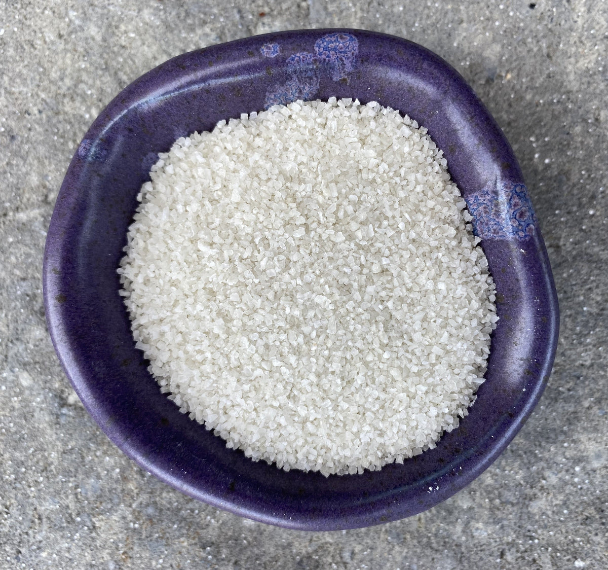 Purple bowl filled with fine white salt crystals