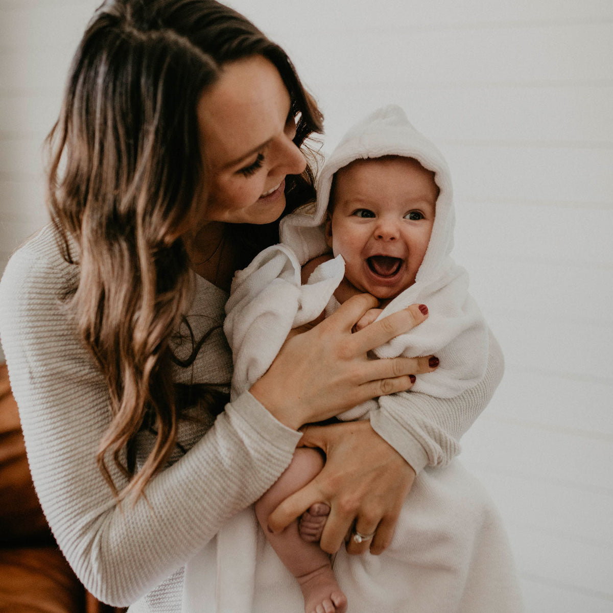 White hooded bath towel with baby wrapped in hood and sleeves
