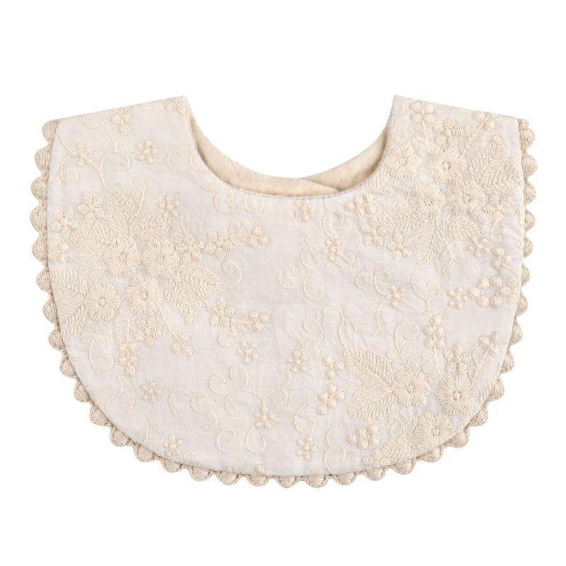 Infant bib with scalloped pom-pom trim, cream with gold floral embroidery pattern
