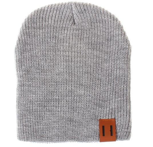 Gray knit beanie hat with foldover cuff and brown logo patch