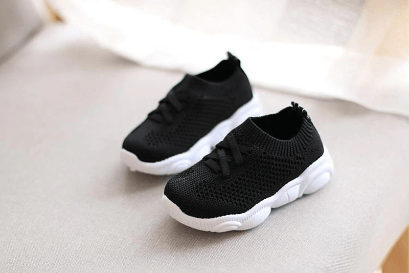 Black knit baby sneakers with lace-up front and white cushioned sole