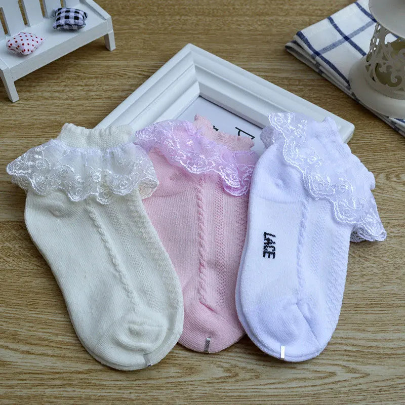 Three pairs lace ruffle ankle socks in cream, pink, and white
