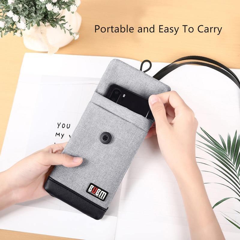 Grey phone wallet bag with flap and snap button; hand holds phone ready to insert