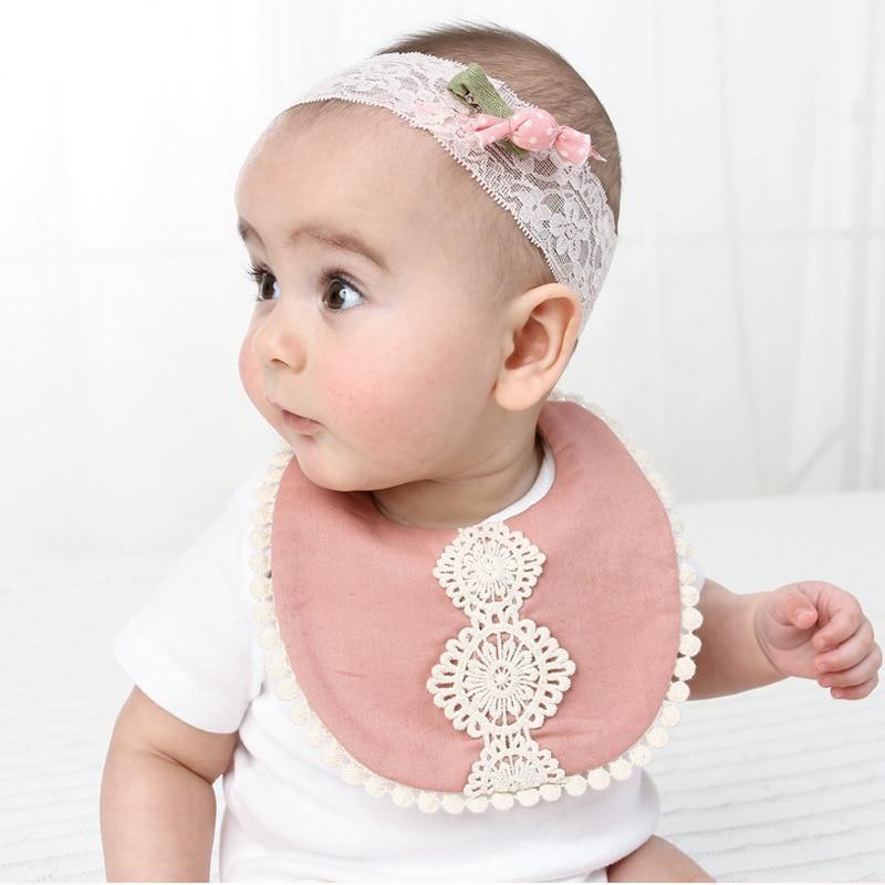 Pink lace-trim baby bib with white floral appliqué