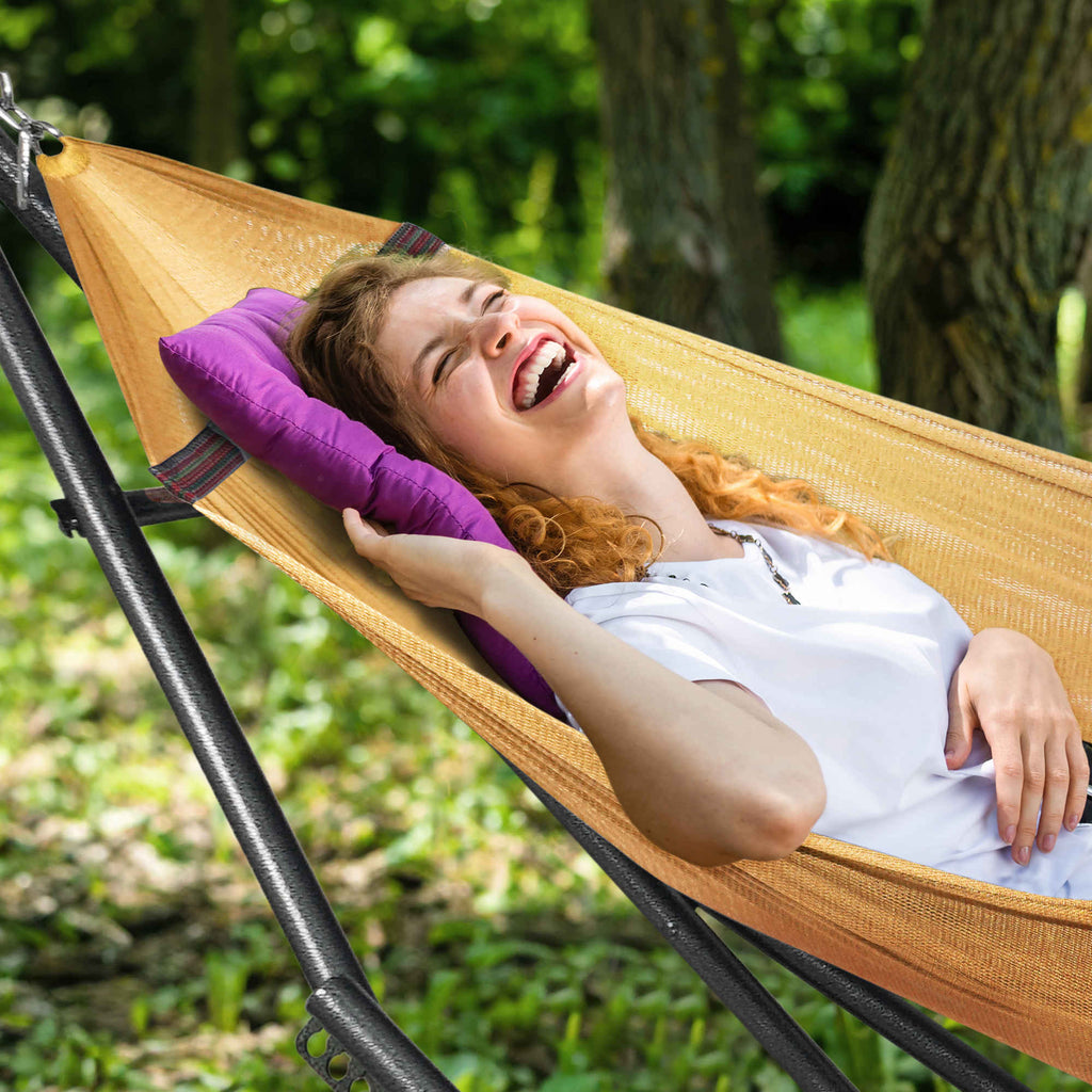 Orange hammock with black stand, person lying on it outdoors