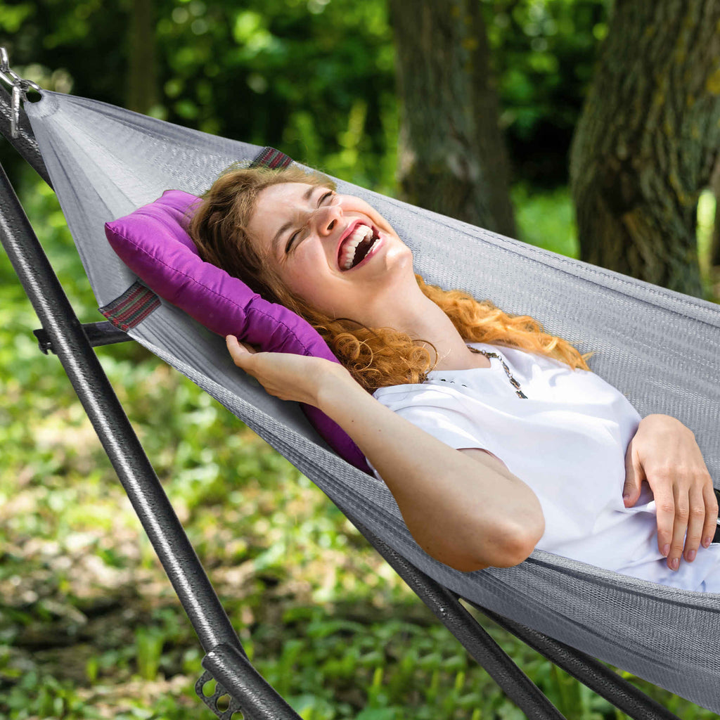 Gray hammock on a black stand with a person relaxing, supported by end frames