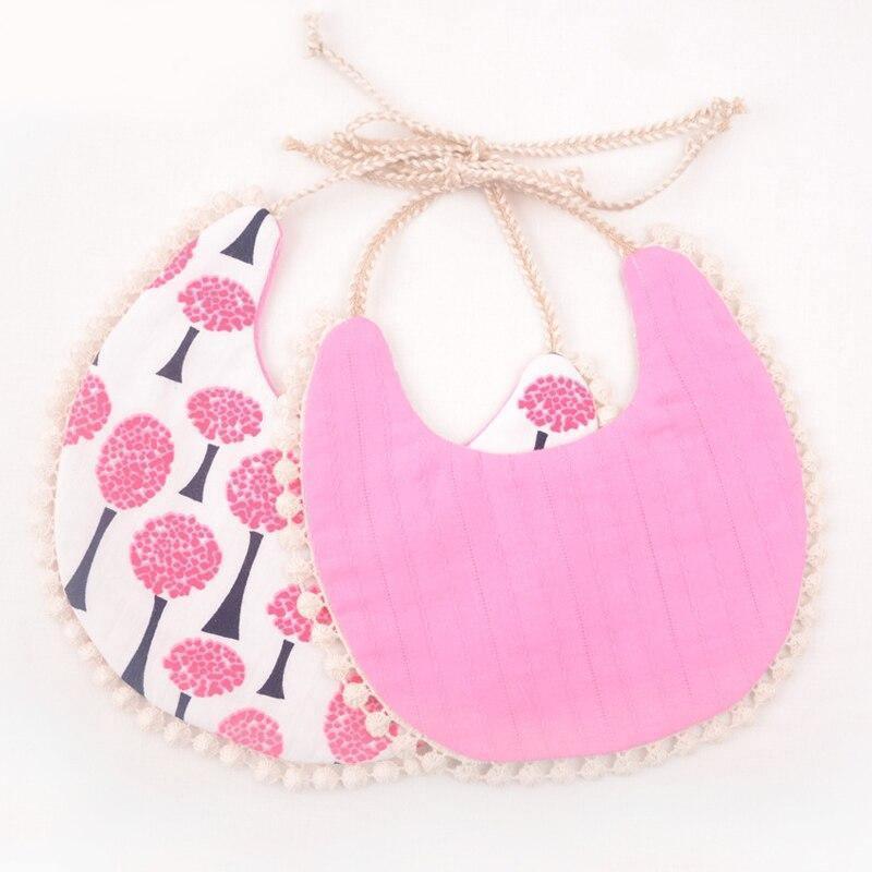 Pink floral and solid pink double bib set with braided ties and tassel trim.