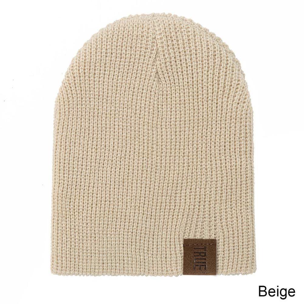Beige knit baby beanie and matching neck warmer with small logo patch