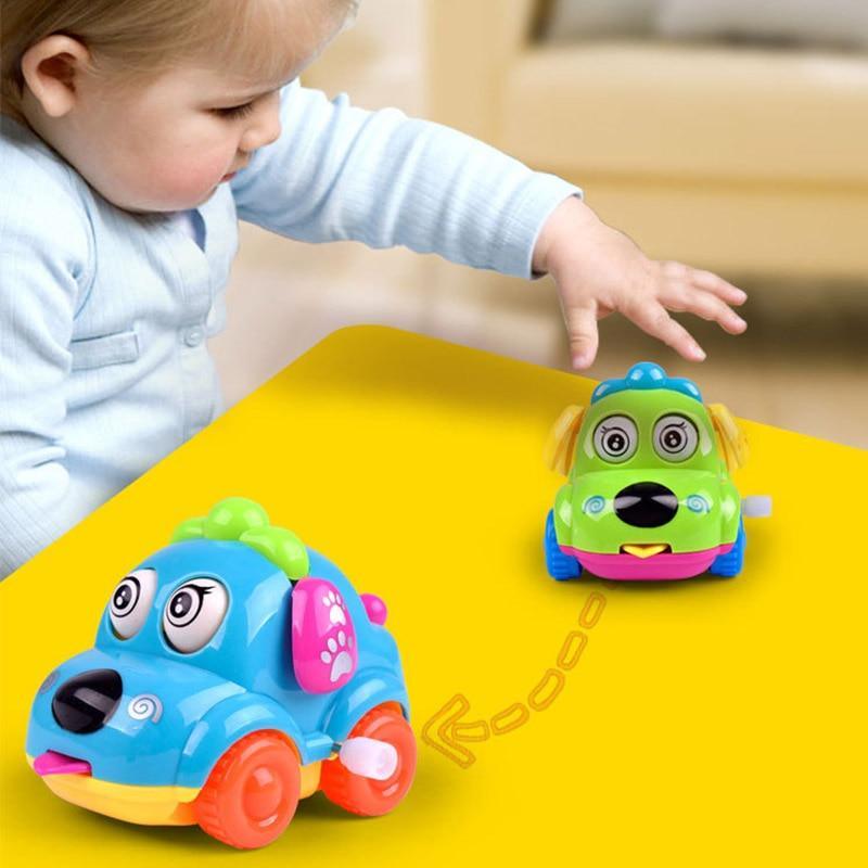 Green cartoon dog wind-up toy car with blue wheels and big smiling face