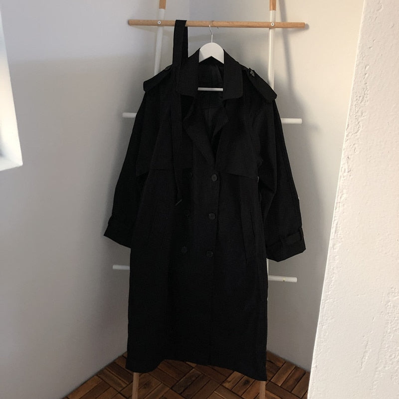 Black long overcoat on hanger, double-breasted button front and belt
