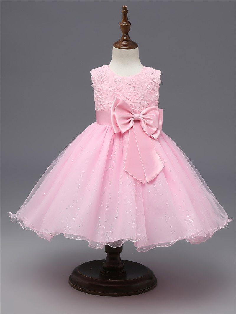 Blush pink tulle dress with large bow at chest and softly layered skirt