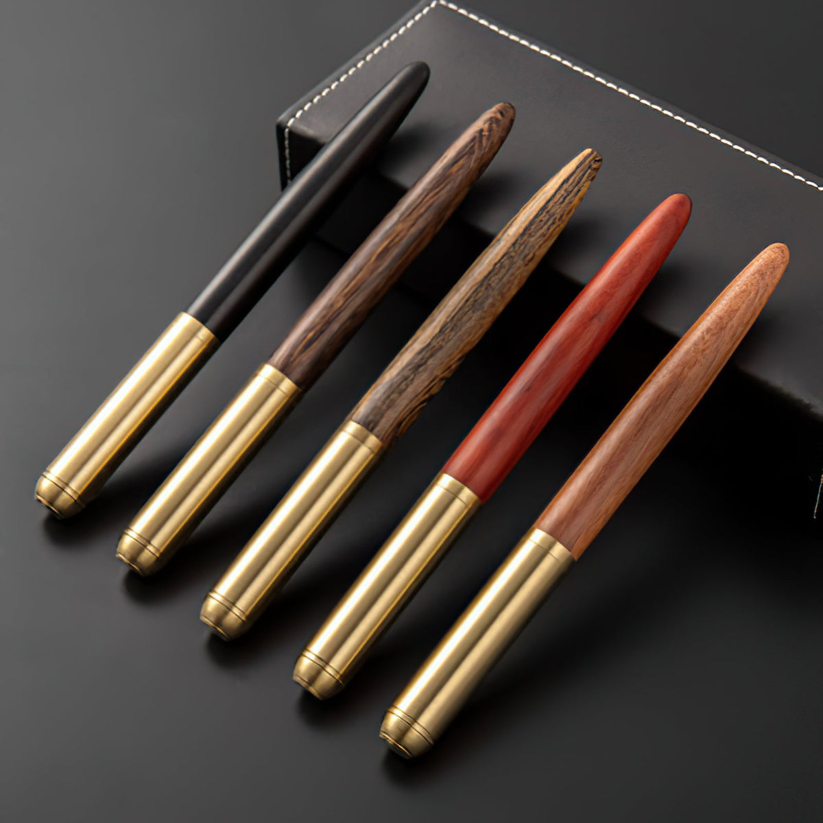 Handmade fountain pen collection with wood barrels and gold-toned tips
