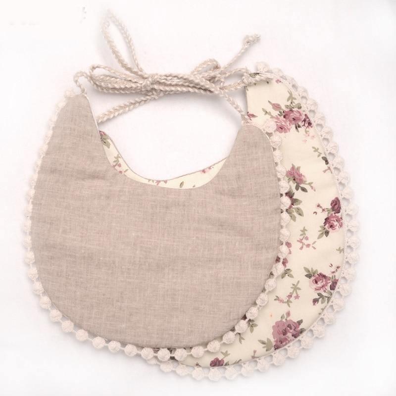 Baby bib set with gray solid front and floral print back, tied with tassel strings