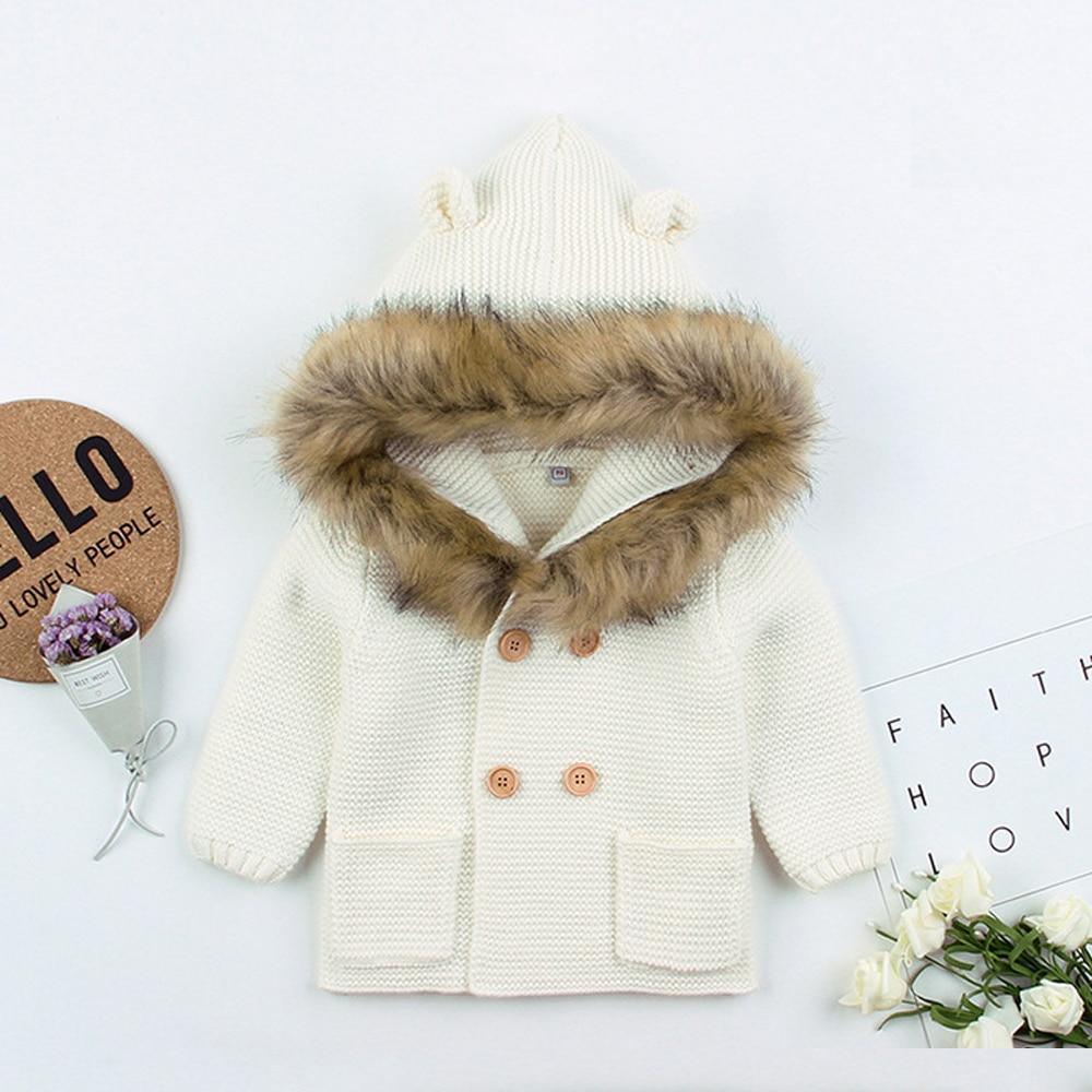 Newborn knitted hooded jacket with faux-fur hood trim and wooden buttons, cream