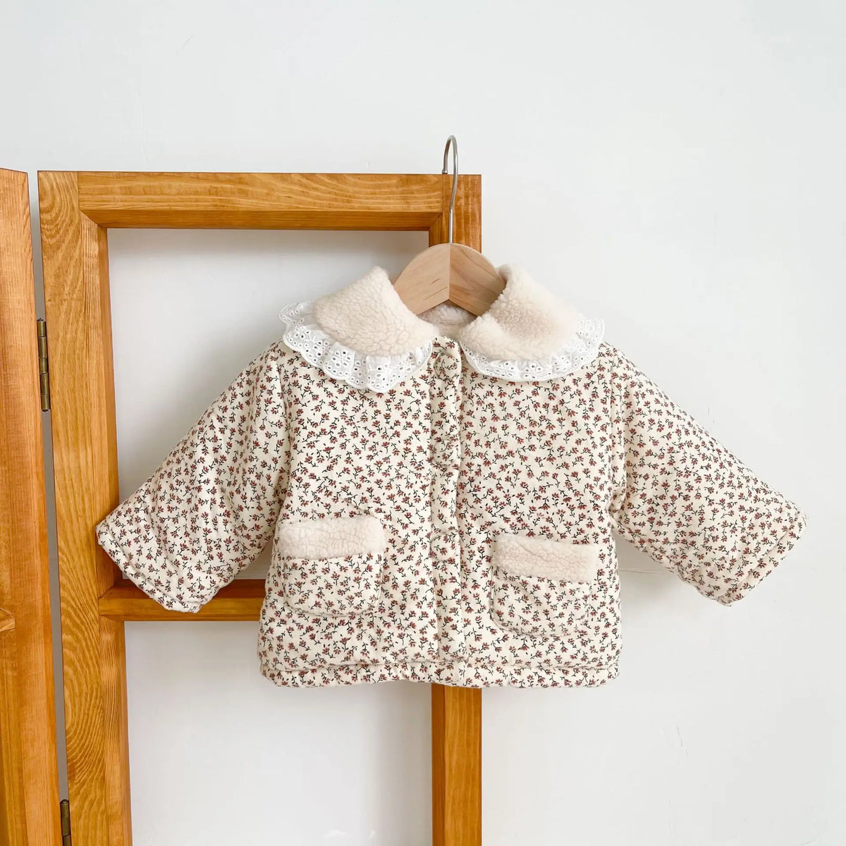 Floral winter baby jacket on hanger with cream sherpa collar and two front pockets
