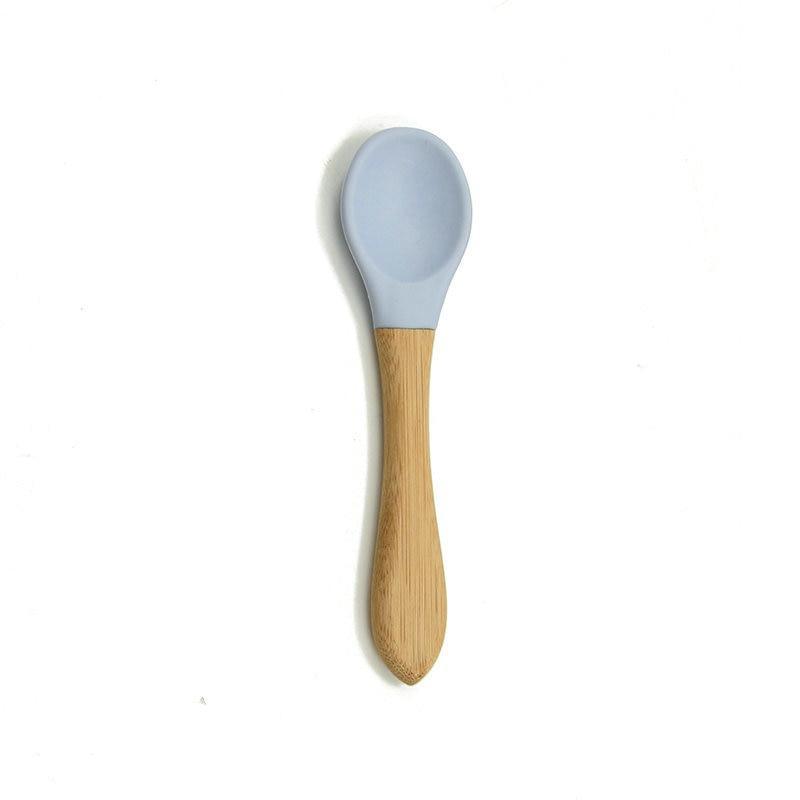 Baby feeding spoon with wooden handle and light blue silicone tip
