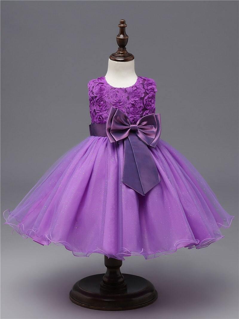 Purple chiffon-style dress with ruffled shoulders and oversized bow at waist