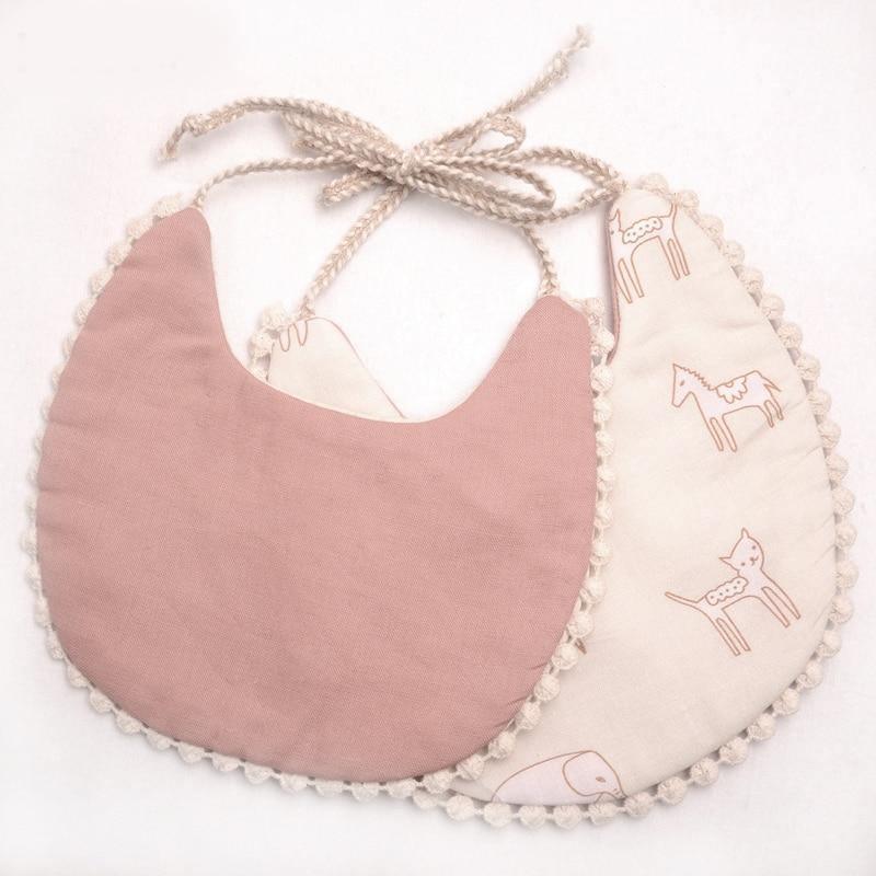 Kids bib set with dusty rose solid front and animal print back, tied with tassel strings