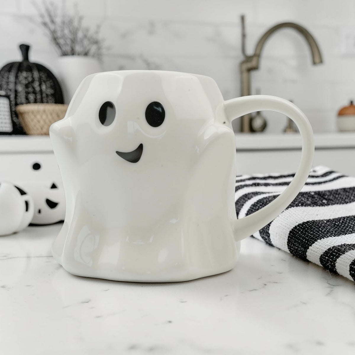 White ghost-shaped mug with black eyes and a smiling face