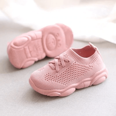 Pink knit baby sneakers with lace-up front and matching pink outsole