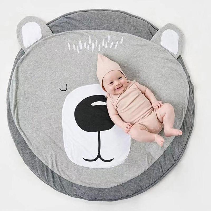 Round baby animal play mat with large bear face print in gray and white.