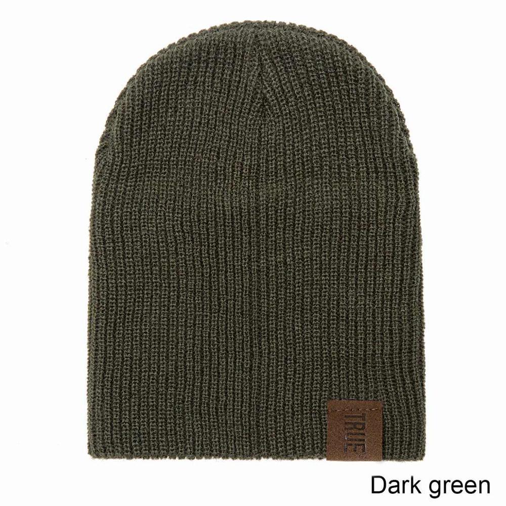 Dark green kids knit beanie hat with ribbed texture and leather brand patch