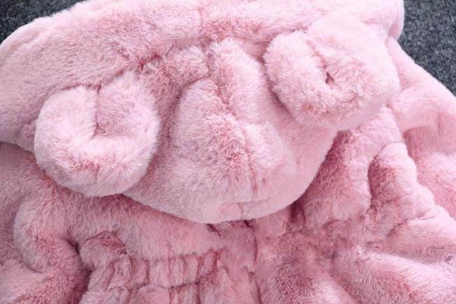 Pink hooded plush jacket close-up, fluffy bear-ear hood and soft sherpa texture