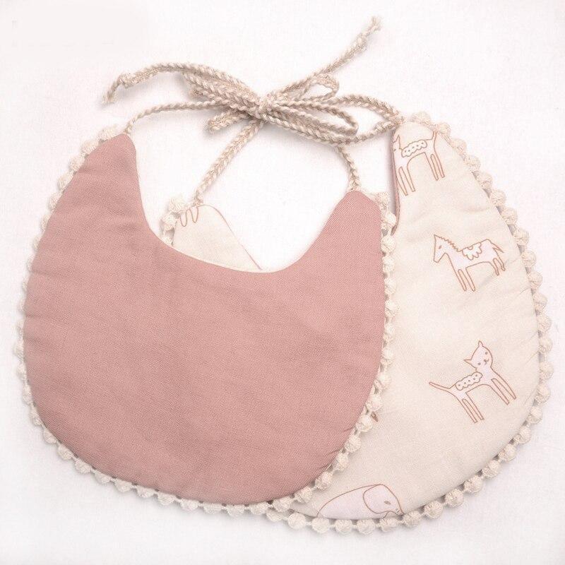 Dusty rose solid and animal print double bib set with pom-pom trim and braided ties.