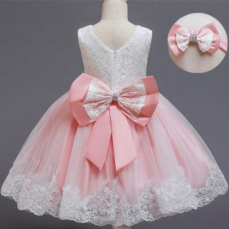 Light pink lace tulle dress with large satin bow on bodice and waist ribbon