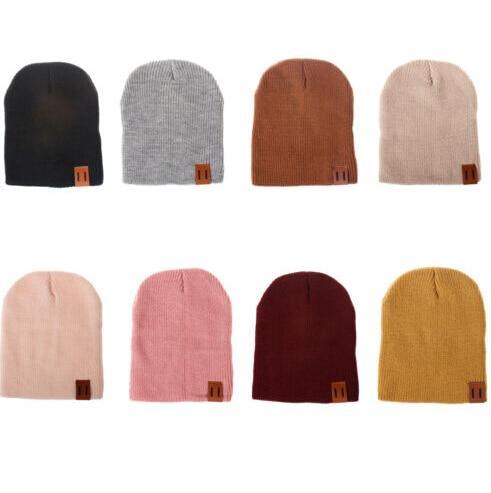 Set of knit beanie hats in black, gray, rust, and beige